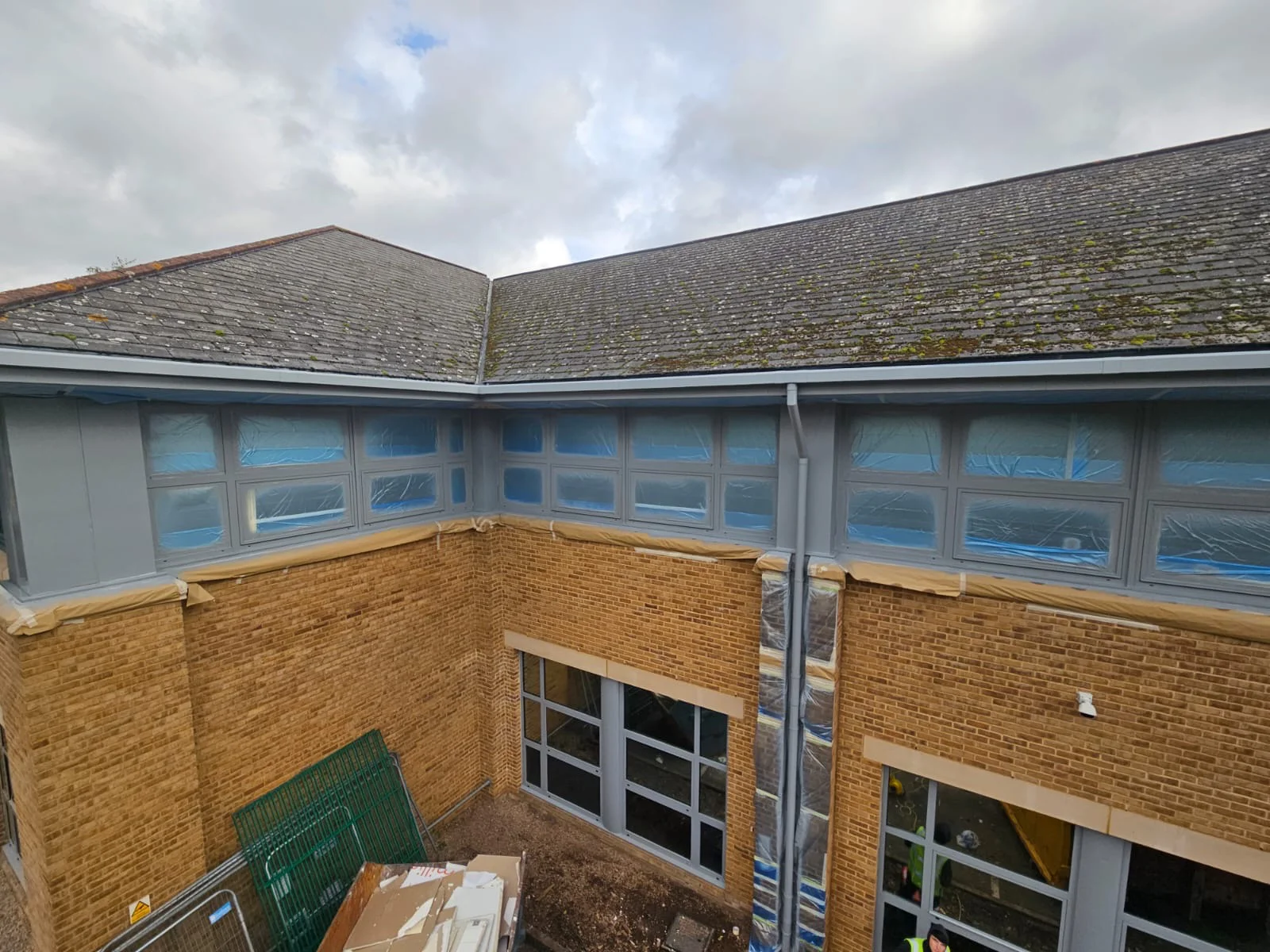 Elevated view of aluminium window frames being resprayed at Birmingham Business Park, blue masking sheeting visible
