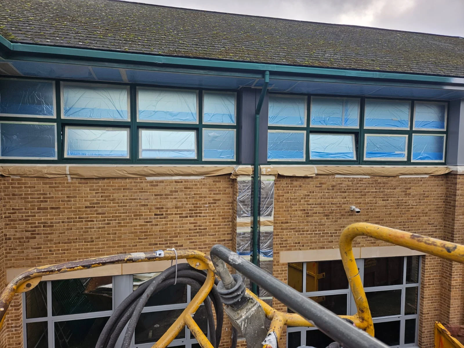 Aluminium window frames masked with protective sheeting prior to respraying at Birmingham Business Park