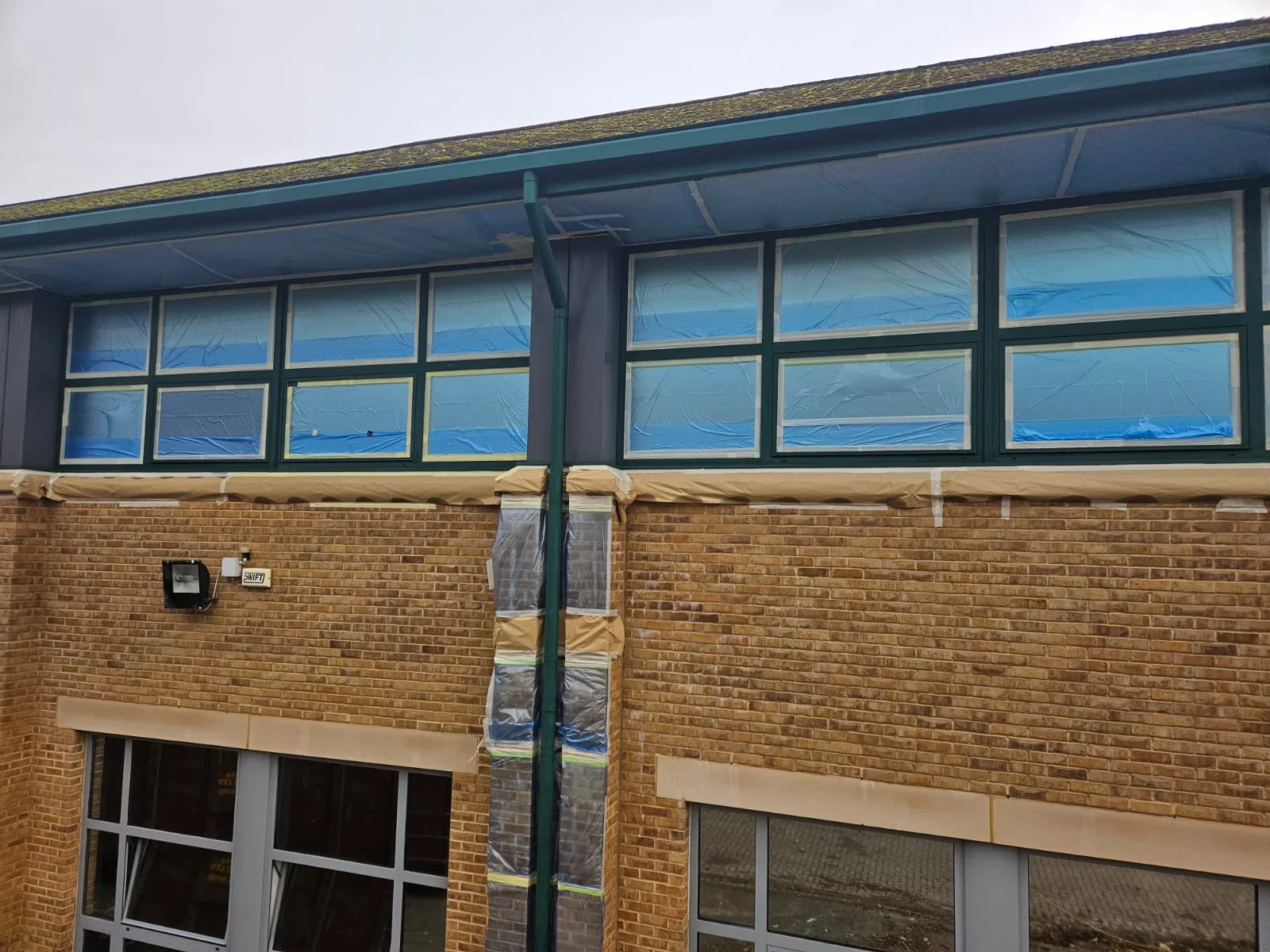 Aluminium window frames at Birmingham Business Park with masking applied, ready for finish coat application