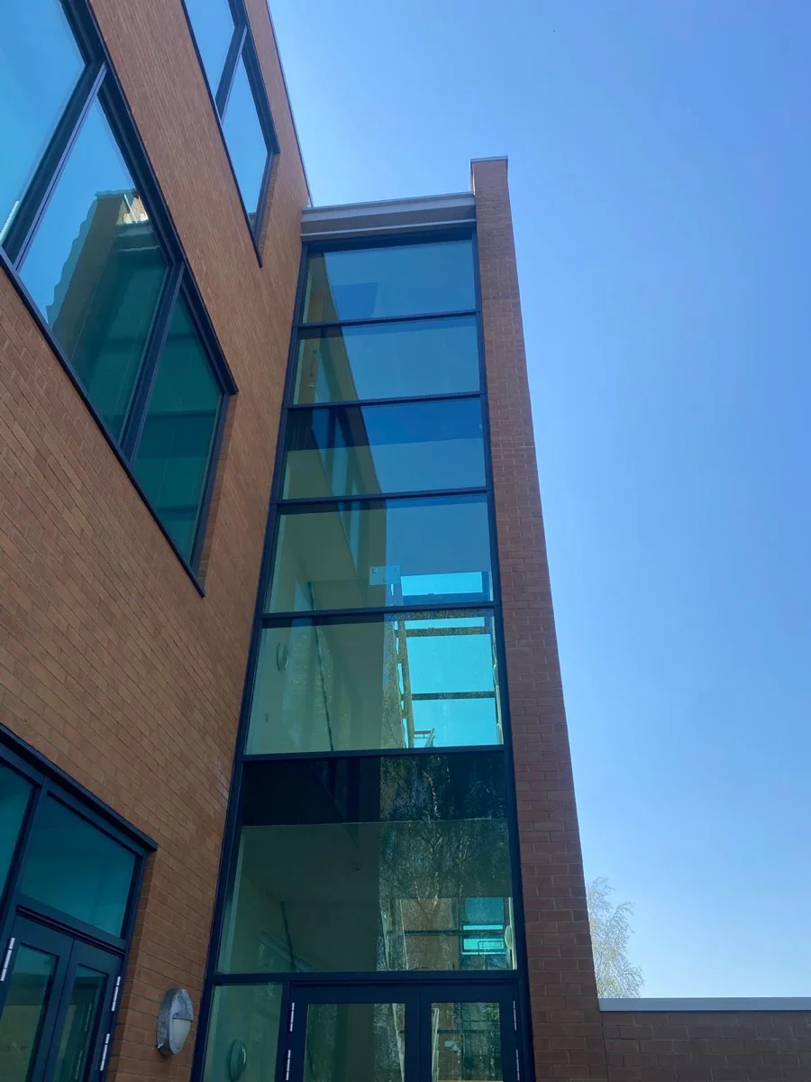 Completed tall curtain wall section at Central Park Manchester, uniform dark frame finish