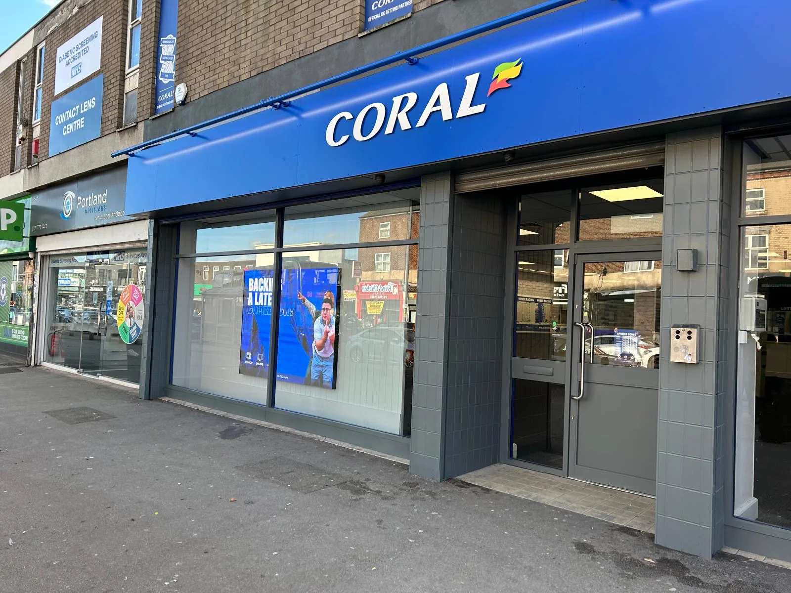 Coral Birmingham shop front before recoating, original blue brand scheme on aluminium frames and fascia