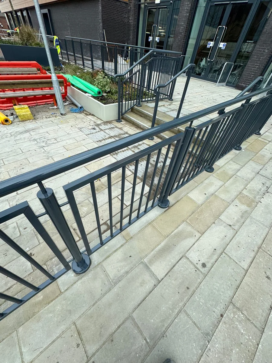 Completed railing sections at Manchester city centre development by Vanda Coatings, uniform dark finish