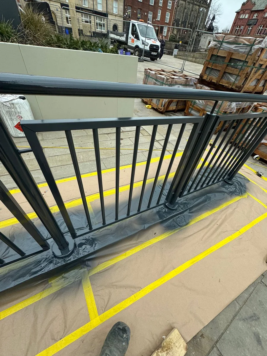 Steel balustrades at Manchester city centre development during spraying works, floor masked with protective sheeting
