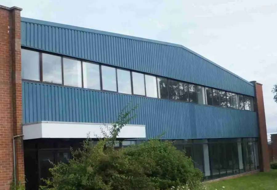 Faded and chalking paint coating on commercial metal cladding panels on a UK building