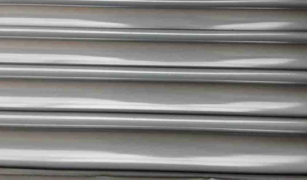 Roller shutter door being spray painted on a commercial premises in the UK