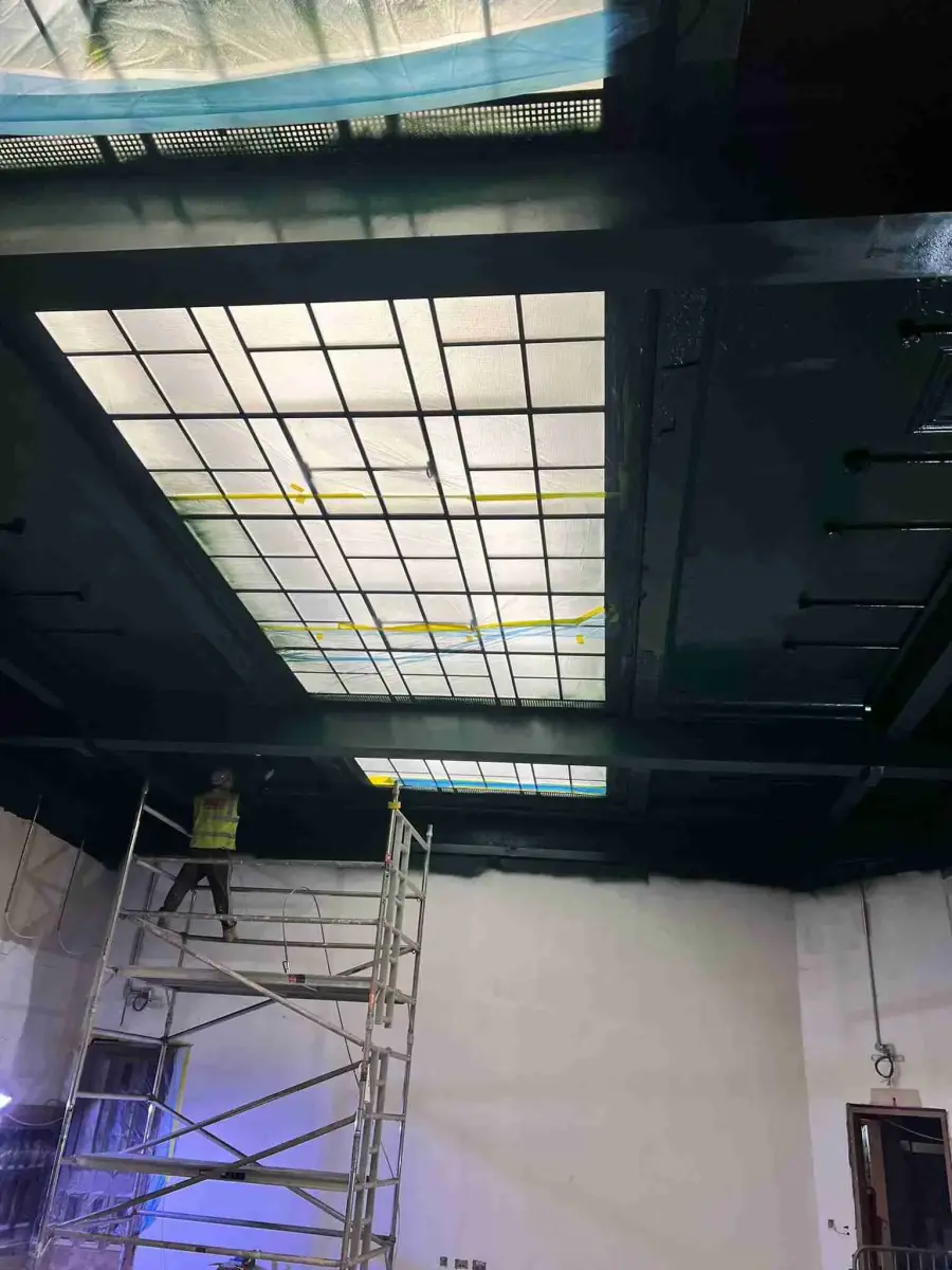 Airless paint spraying being applied to commercial metalwork on site