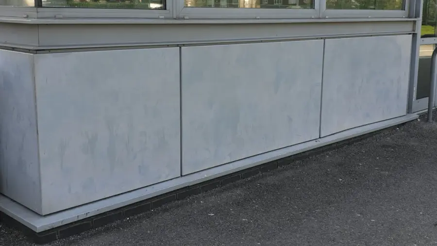 Faded and chalking powder-coated aluminium on a commercial building elevation