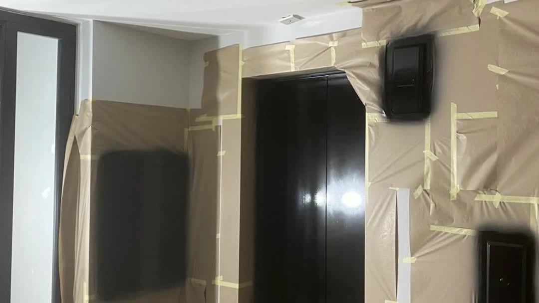 Completed lift door recoating to jet black finish at a London office building by Vanda Coatings