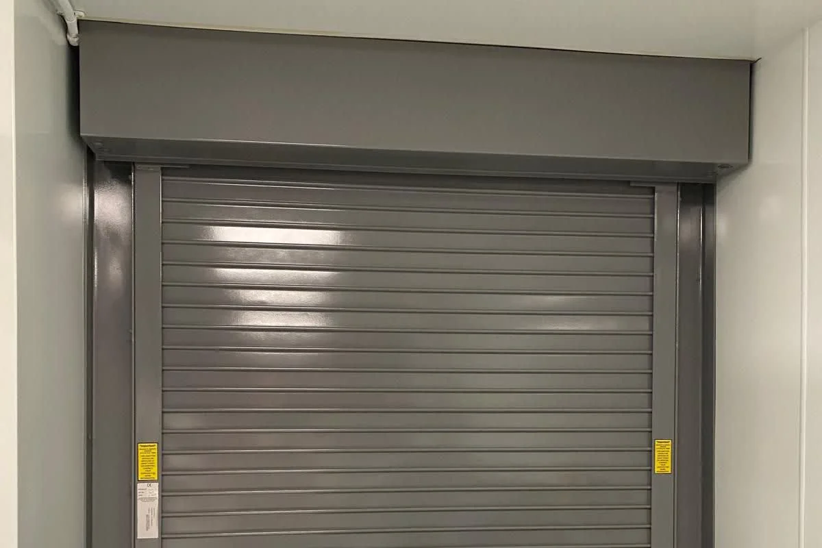 Freshly coated grey roller shutter door in a commercial building by Vanda Coatings
