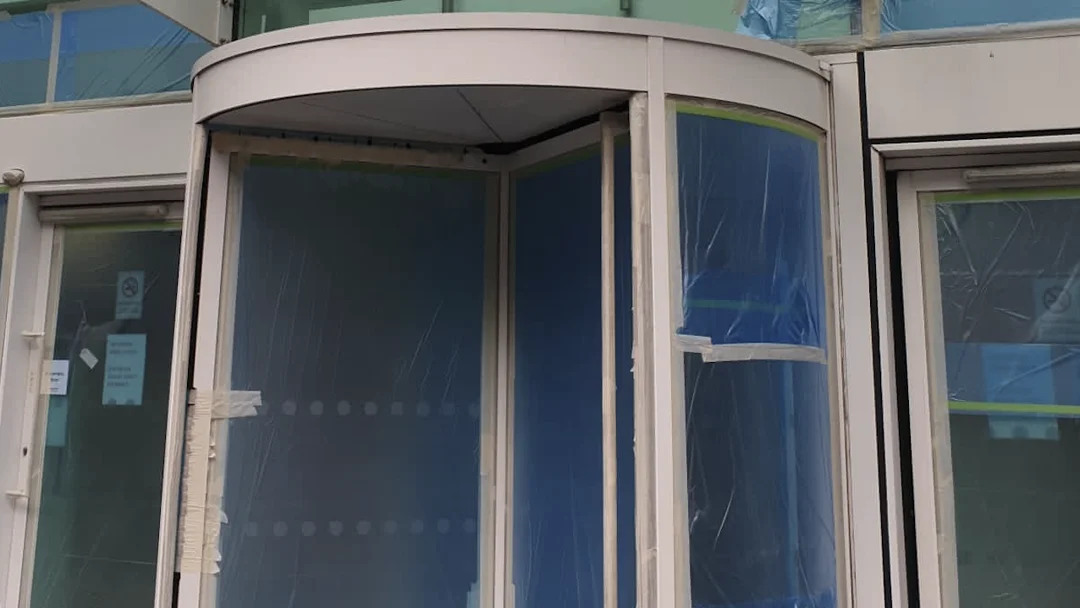 Liverpool Passport Office revolving door primed and glazing masked, during recoating by Vanda Coatings