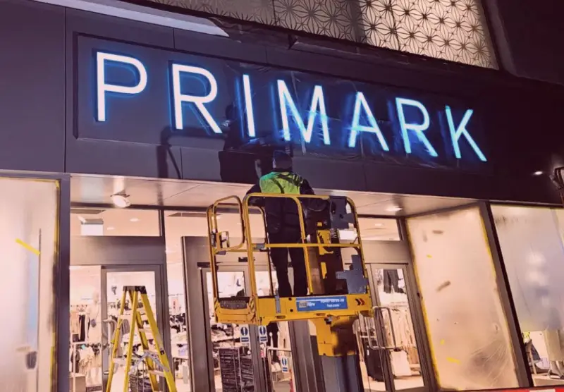 Vanda Coatings operative spraying a retail fascia at night as part of a national rollout programme