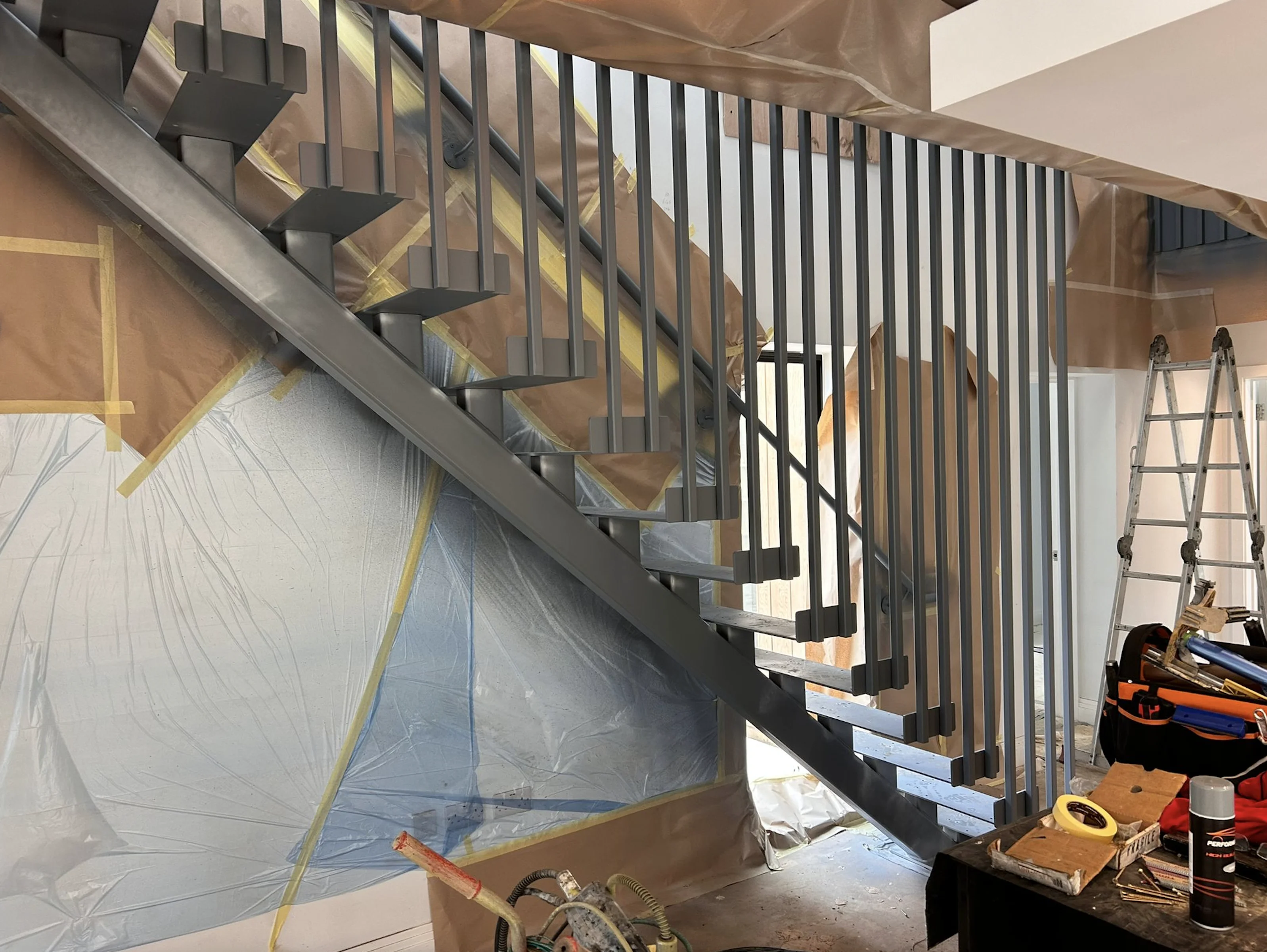 Steel staircase balustrade masked and spray-painted on site by Vanda Coatings operatives